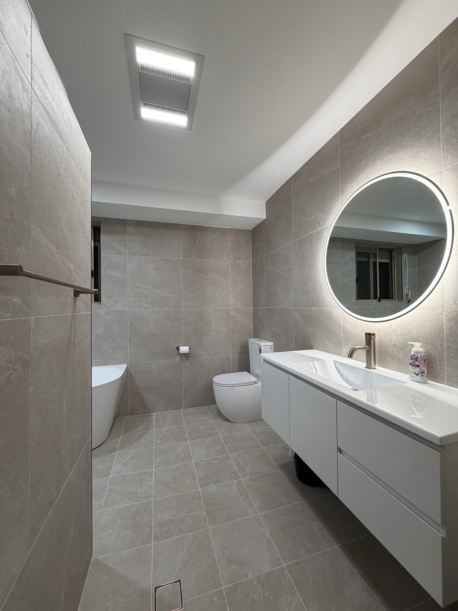 Bathroom with backlit mirror and heat lamp