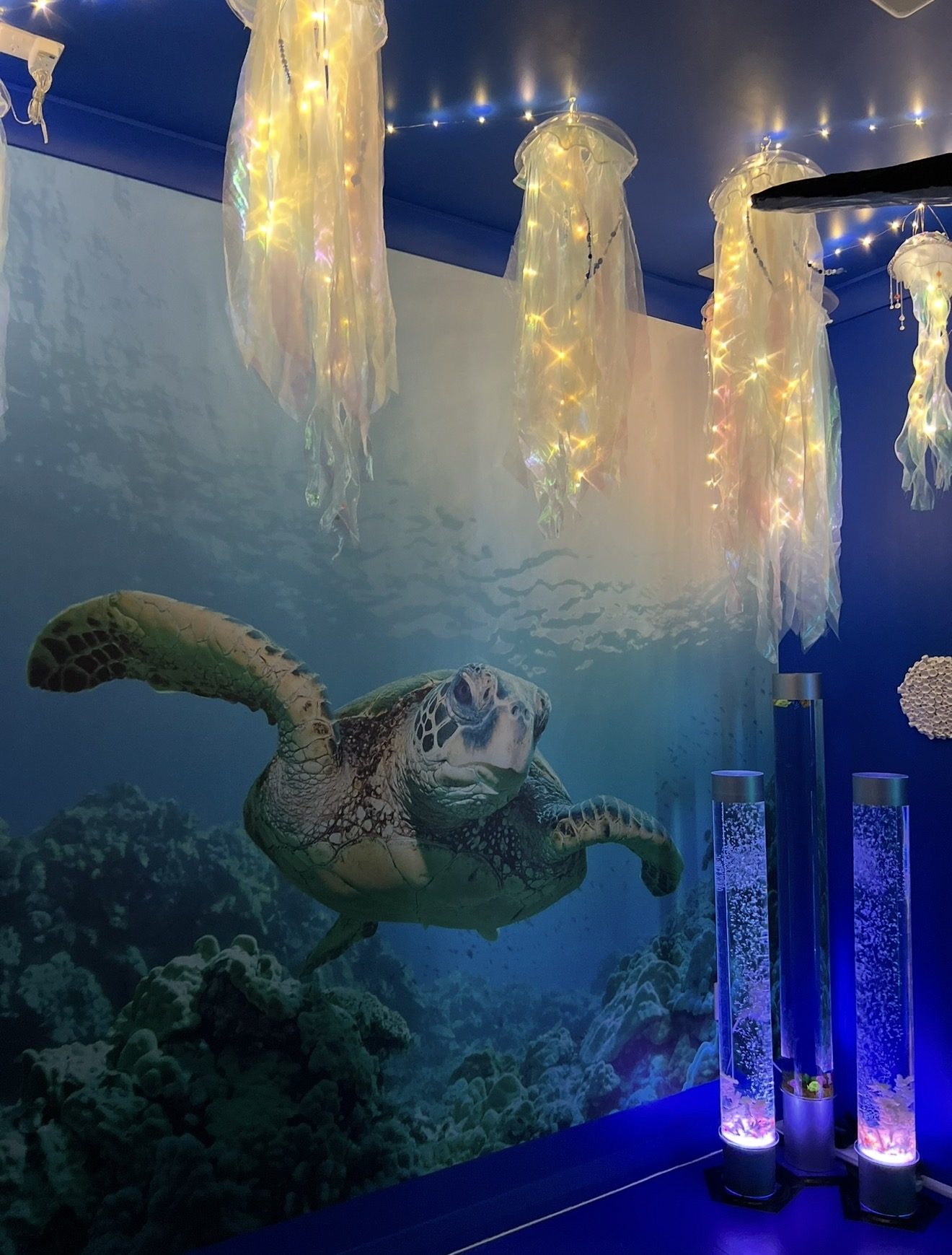 Jellyfish pendant lights over an underwater mural